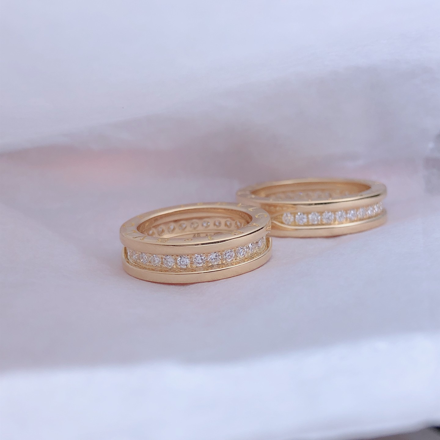 B.zero1 one-band couples' rings in 18k gold, one of which is set with pavé diamonds on the spiral.