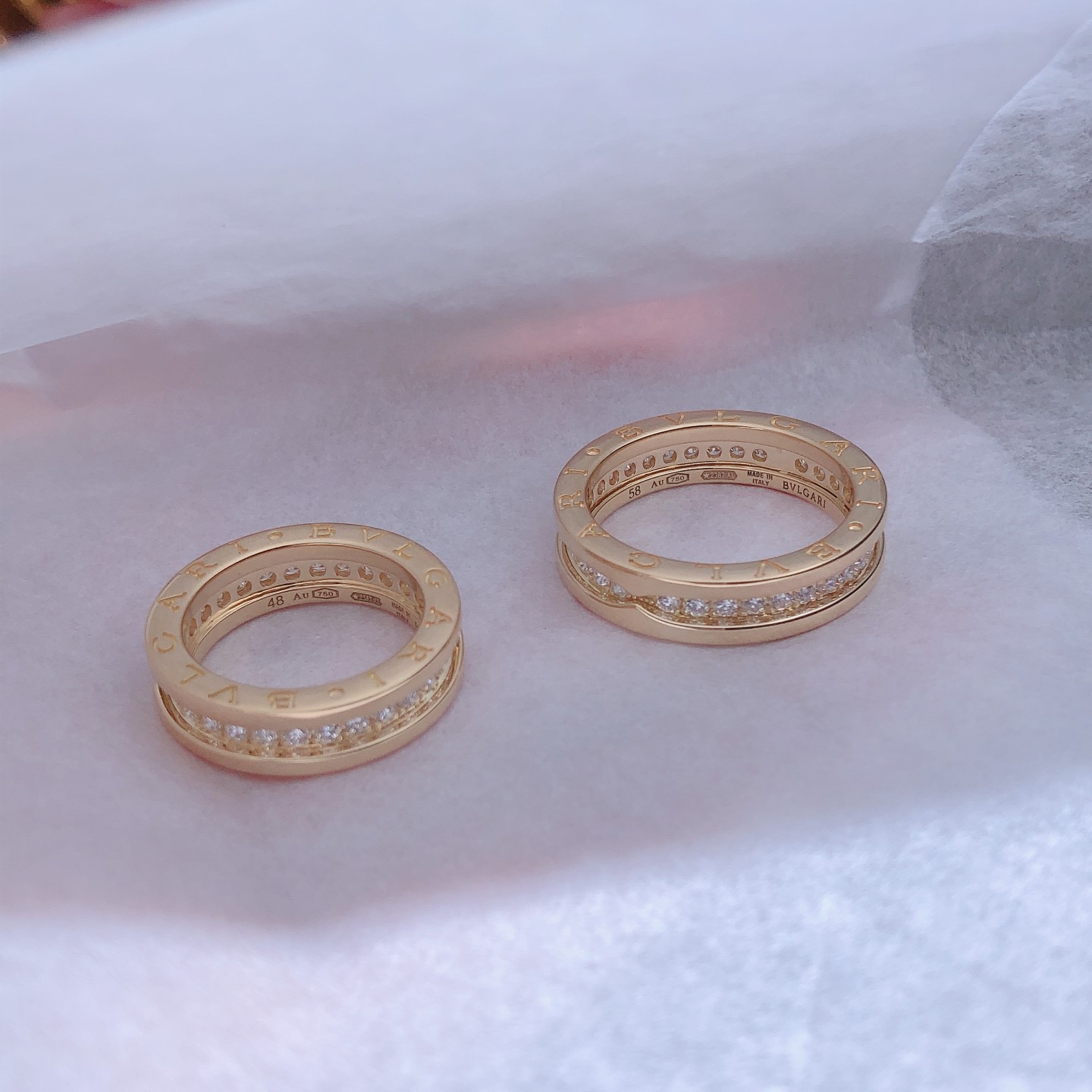 B.zero1 one-band couples' rings in 18k gold, one of which is set with pavé diamonds on the spiral.