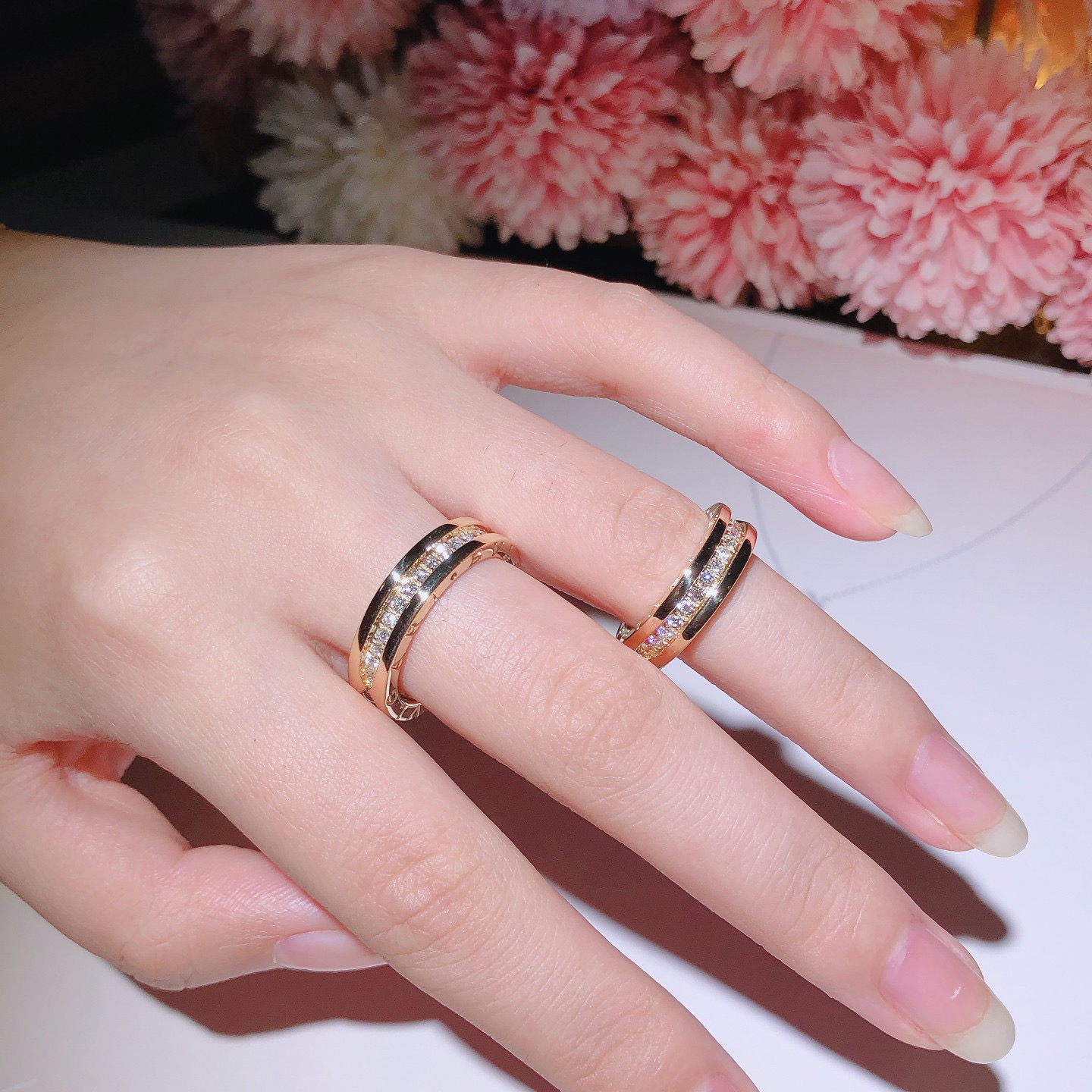 B.zero1 one-band couples' rings in 18k gold, one of which is set with pavé diamonds on the spiral.