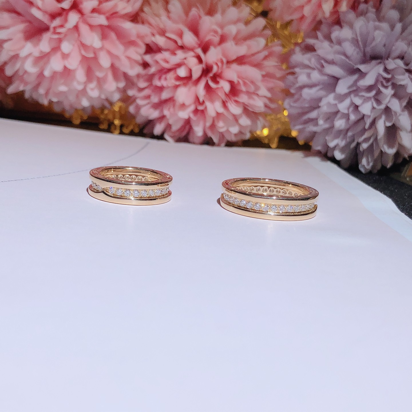 B.zero1 one-band couples' rings in 18k gold, one of which is set with pavé diamonds on the spiral.