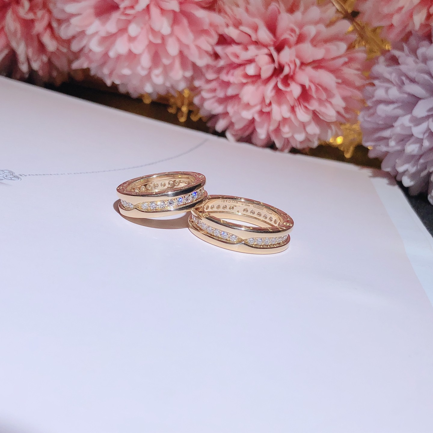 B.zero1 one-band couples' rings in 18k gold, one of which is set with pavé diamonds on the spiral.